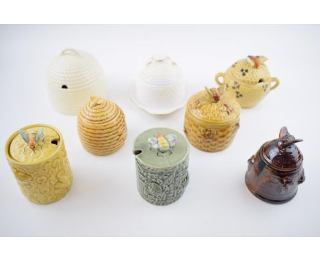 A collection of pottery honey pots in varying forms and colours to include a Wedgwood Queensware cream basket weave example, 