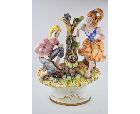 Large Cape De Monte figure. Depicting a young man and woman by a tree stump in springtime. Has the option to stand alone as a