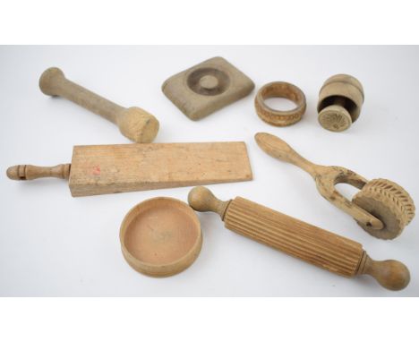 A collection of treen antique and vintage kitchenalia items to include biscuit moulds, rolling pins and other similar items. 