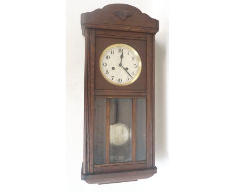OAK CASED REGULATOR WALL CLOCK
in a shaped case with a circular silvered dial above a silvered pendulum, with key, 76.5cm