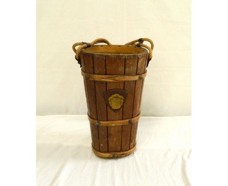 OAK STICK STAND
of tapering form with stud work banding and a gilt metal heraldic crest, with a rope twist handle, 46cm high 