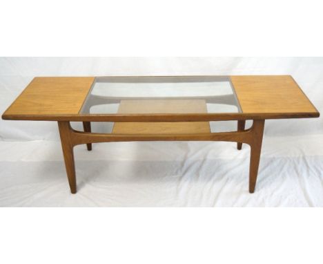 1970's RECTANGULAR TEAK OCCASIONAL TABLE
with an inset glass top and a shelf below, standing on shaped tapering supports, 137