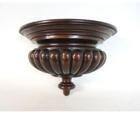 MAHOGANY DEMI LUNE WALL BRACKET 
the moulded top above tapering drops with a finial below, 33cm wide