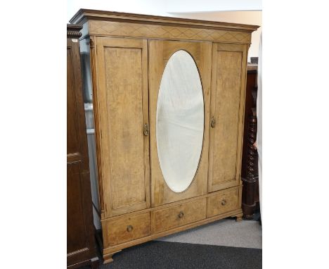 WALNUT AND FIGURED WALNUT WARDROBE
the moulded cornice with a diamond motif frieze above an oval bevelled mirror door flanked