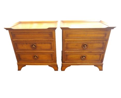 PAIR OF CHINESE STYLE CHERRY BEDSIDE CHESTS 
with swing out tray tops above three drawers, standing on splayed bracket feet, 