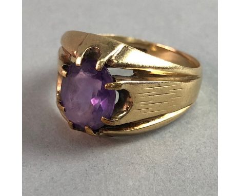 NINE CARAT GOLD GEM SET RING, set with an oval purple gem, on trifuracted shoulders, size R, 6.1g