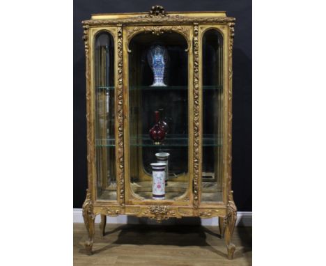 An early 20th century French giltwood and gesso vitrine or display cabinet, enclosing two shelves, cabriole forelegs, 163.5cm
