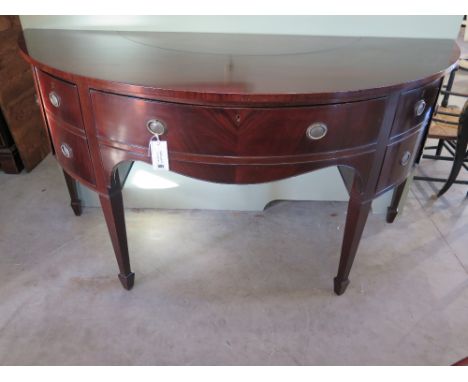 An early 19th century mahogany bowfronted sideboard with a central drawer flanked by cupboards and a single decanter drawer o
