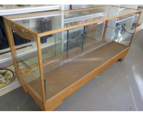 A glazed shop display cabinet with sliding rear doors and a single glass shelf 180cm wide x 91cm high x 57cm