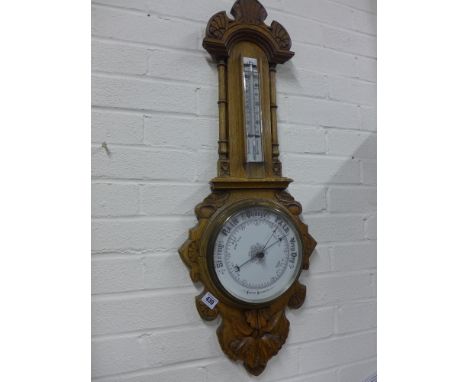 A carved aneroid barometer with thermometer - Height 87 cm 
Condition report:  Two pieces of moulding missing 