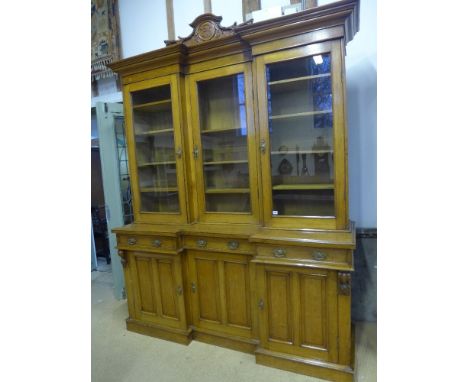 A good late Victorian blonde oak inverted breakfront bookcase sideboard with three glazed doors above three drawers and three