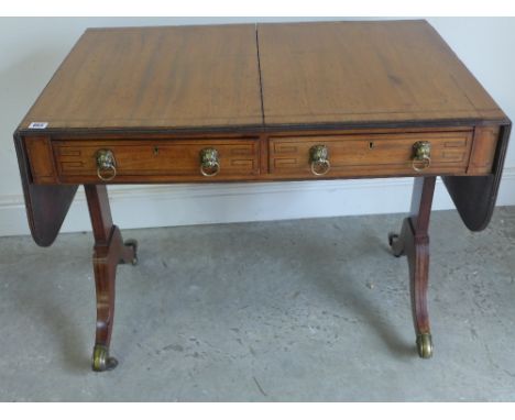 A 19th century mahogany and inlaid sofa table on lyre end supports