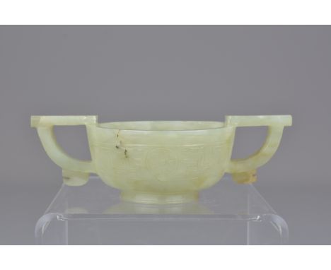 A Chinese 17th century late Ming carved celadon ceremonial jade wine cup with twin handles. 12cm width. Provenance: Held in p