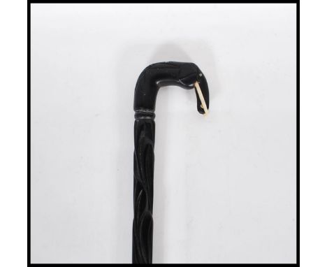 A vintage 20th Century ebony walking stick cane. The handle in the form of an elephant with carved creature to the top with a