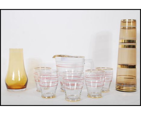 A mid 20th Century lemonade set consisting of a lemonade pitcher together with matching glasses having alternative red and wh