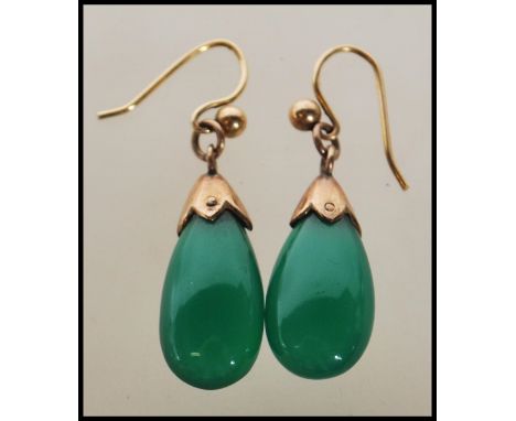 A pair of 20th century vintage ladies drop earrings set with polished teardrop green jade style stones on a gold mounts. Gold