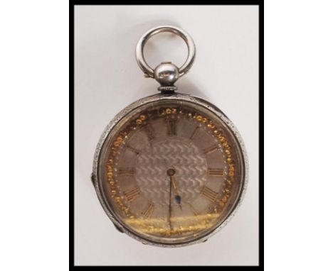 An early 20th Century silver pocket watch having a silvered engine turned dial with gilt roman numerals to the chapter ring, 