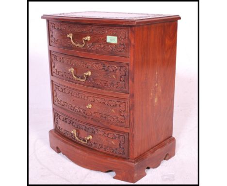 A 20th century contemporary hardwood marquetry inlaid chest of four drawers. The chest having brass and copper inlay details,