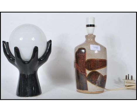 Two vintage mid 20th Century table lamps / lights to include a black glass lamp in the form of two hands holding a round glob