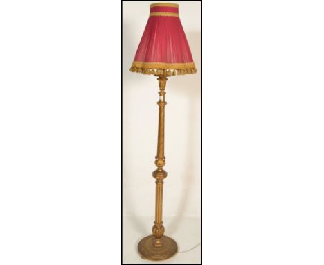 A 20th Century gesso gilt standard floor lamp, acanthus leaf terminus with reeded column upright with a red and gilt tasselle