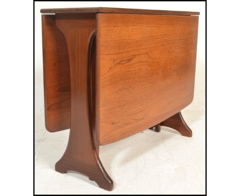A 1970's teak wood Danish influenced G-Plan drop leaf dining table raised on shaped supports with full length drop leaves hav