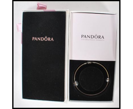 A stamped 925 silver Pandora charm bracelet bangle. The&nbsp;circular bangle having Pandora clasp&nbsp;with two charms one of