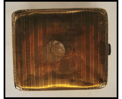 A mid 20th Century gilt silver vesta case having an engine turned decoration with an oval panel to the front with scrolled de