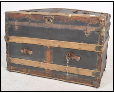 A vintage 19th century wooden and canvas bound steamer trunk. The dome top with open storage within. Ebonised canvas and wood
