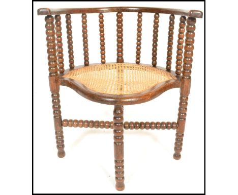 A 19th Century Victorian William and Mary revival corner chair having turned bobbin stretchers to the back rest raised on fou