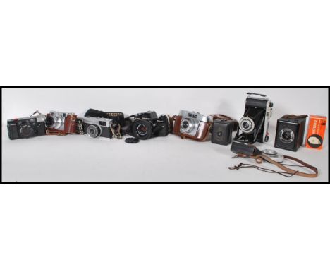 A collection of vintage film cameras to include a Praktica B100 film camera, an Olympus Quick Flash AFL, a folding Kodak Juni