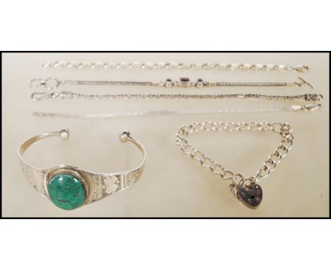 A group of silver bracelets to include a silver bangle having engraved decoration and a central malachite cabochon, flat link