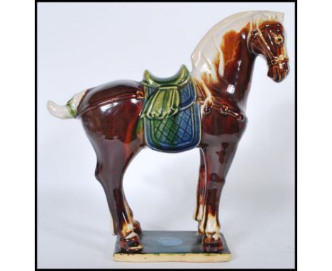 A good 20th Century Chinese Tang dynasty style war horse moulded to a rectangular ceramic base. Having a majolica style drip 