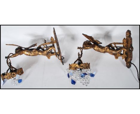 A pair of 20th Century wall mounted gilt cast metal light fixture chandeliers in the form of cherubs holding chandeliers with