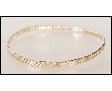 A hallmarked 9ct gold three tone twist design bangle bracelet. Hallmarked London (date marks rubbed). Weight 13.3g.&nbsp;