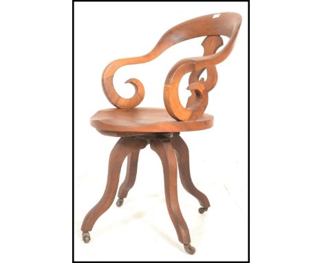 A 19th Century Victorian walnut captains swivel desk chair, scroll shaped armrests and back with fret pierced splat back over