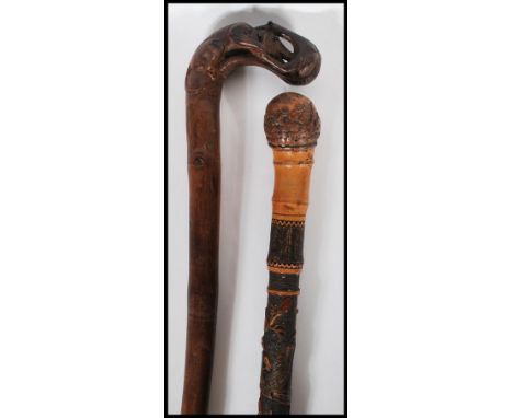 A 20th Century carved bamboo Japanese style walking stick cane decorated with carved blossoms and birds having a root knot ba