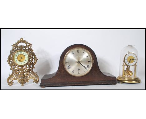 An early 20th century gilt metal mantel clock with rococo design together with a 1920's Napoleons hat mantel clock and a bras