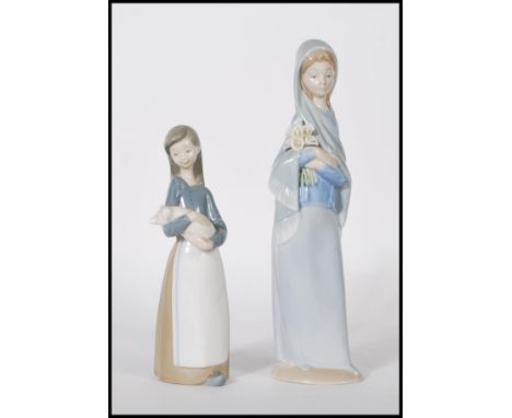 Lladro - A pair of 20th Century porcelain ceramic figurines comprising: 4650 Girl with Calla lilies and 1011 Girl with pig / 