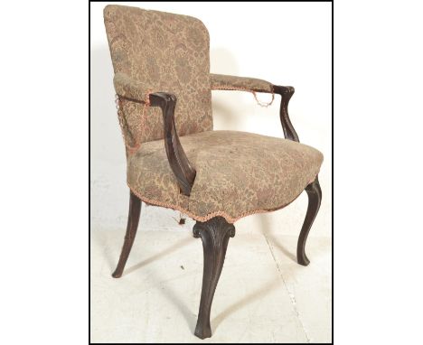 A 19th century French empire mahogany fauteuil armchair being raised on cabriole legs with a tapestry upholstered overstuffed