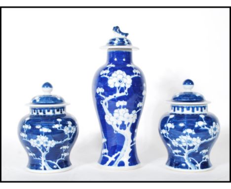 A harlequin garniture of three Chinese blue and white lidded jars to include a pair of ginger jars of waisted form hand paint