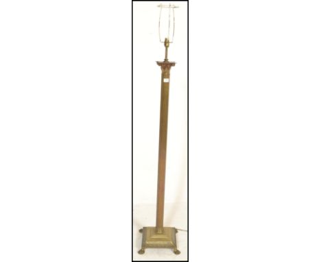 A 19th Century Victorian antique brass standard floor lamp having a stepped base with foliate detailing, raised on lions paw 