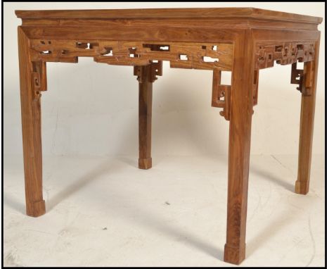 A 20th Century Chinese hardwood dining table of square form,&nbsp;with a foliate carved frieze, on square section legs with s