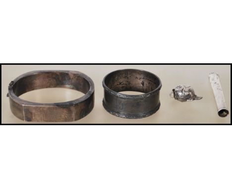 A collection of silver items to include a silver slave bangle in the brutalist manner stamped 925 together with a silver fish