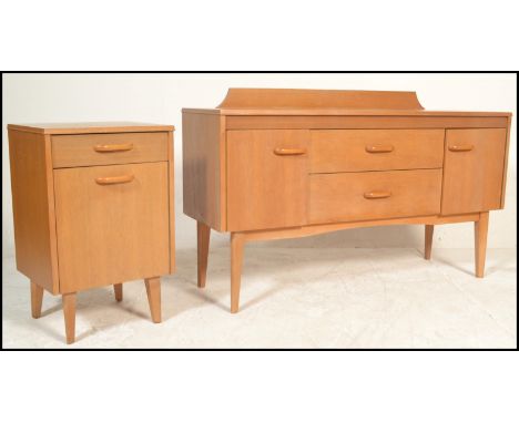 A retro 20th Century light teak wood sideboard having a back rail with a bank of two drawers to the center flanked by cupboar