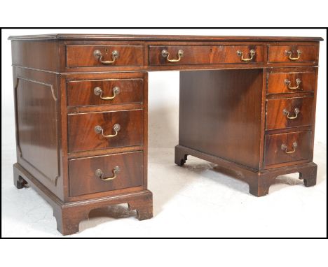 An antique style mahogany and tooled leather twin pedestal writing desk. Raised on bracket feet with drawers to each pedestal