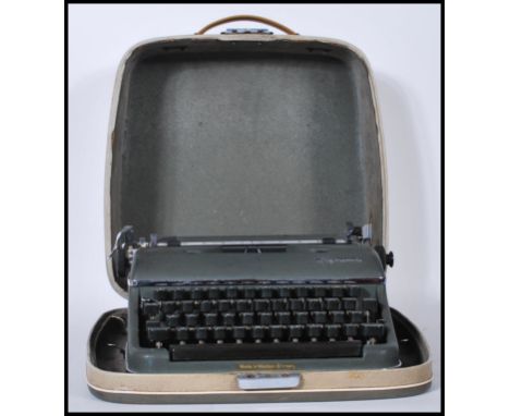 A vintage mid 20th Century Olympia typewriter in army green set within its original fitted carry case, applied makers label t