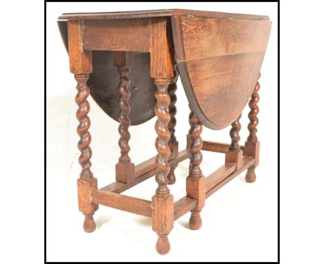 A 1920's early 20th Century good quality light oak drop leaf dining table being raised on barley twist legs united by stretch