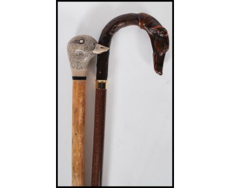 Two&nbsp; 20th Century walking stick canes to include a walking stick with a faux wooden handle in the form of a greyhound an