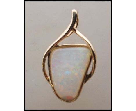 A stamped 14ct gold pendant having a crossover design set with an opal panel. Weight 1.5g. Measures 2.5cm tall.&nbsp;