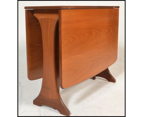 A 1970's teak wood Danish influenced G-Plan drop leaf dining table raised on shaped supports with full length drop leaves hav